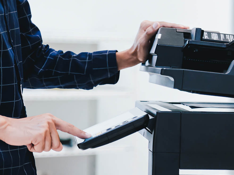 Photo of employee using an offie printer/copier.
